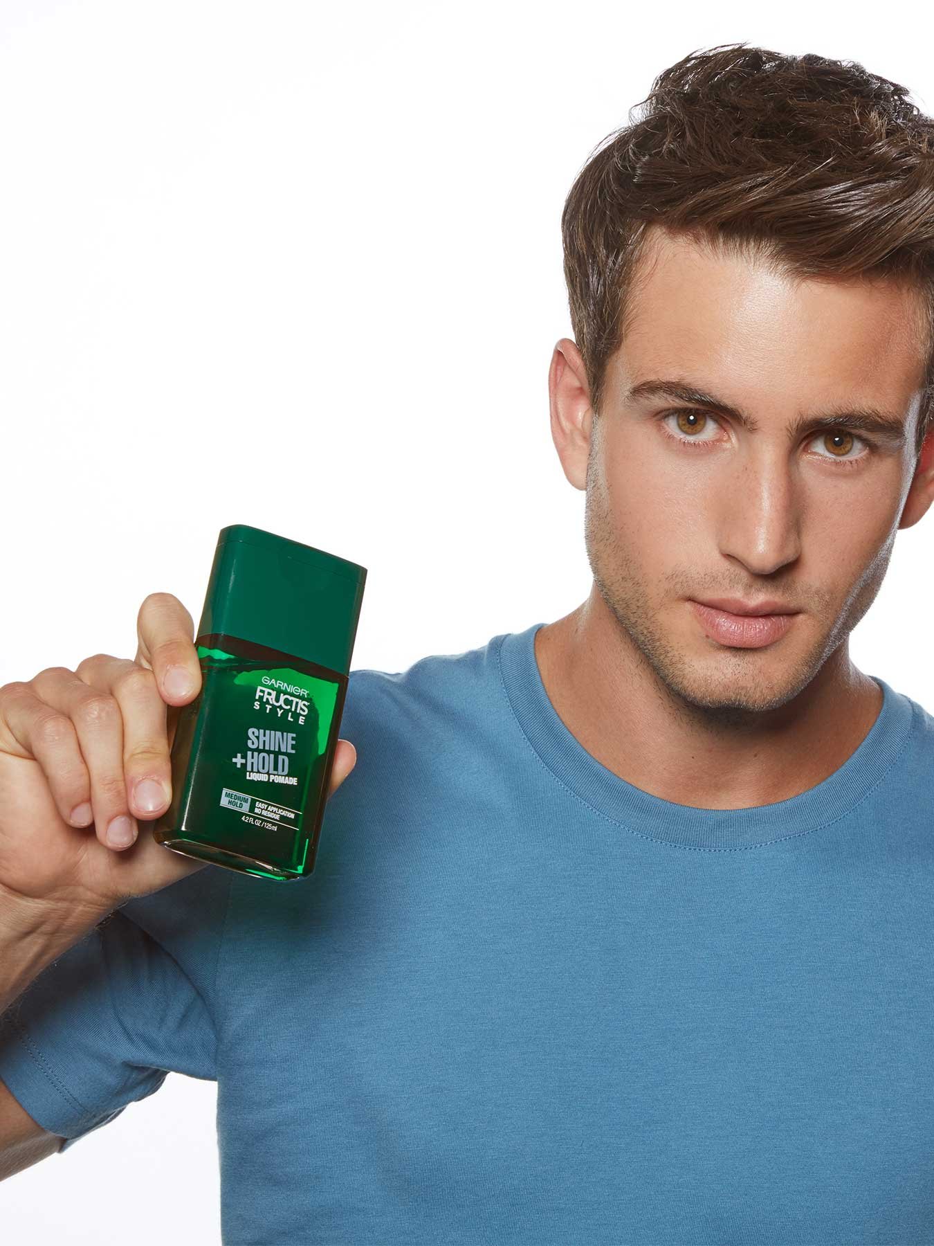 Hand holding Shine and Hold Liquid Hair Pomade for Men, No Drying Alcohol.